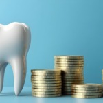 セラミックの歯と金貨で高額をあらわすイメージ