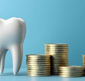 セラミックの歯と金貨で高額をあらわすイメージ